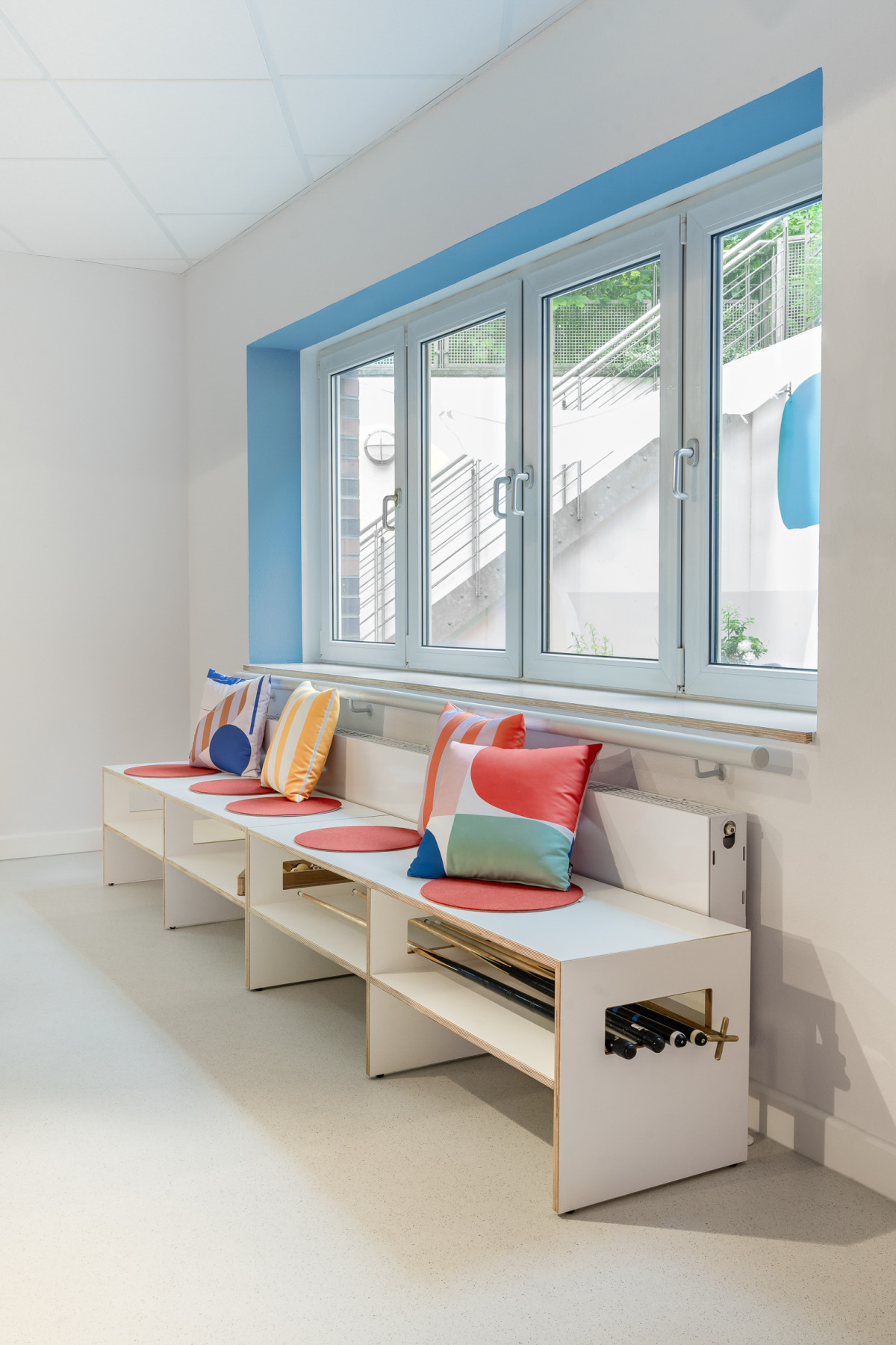 Sitzbank Thomas seitlich mit Queues und bunten Kissen