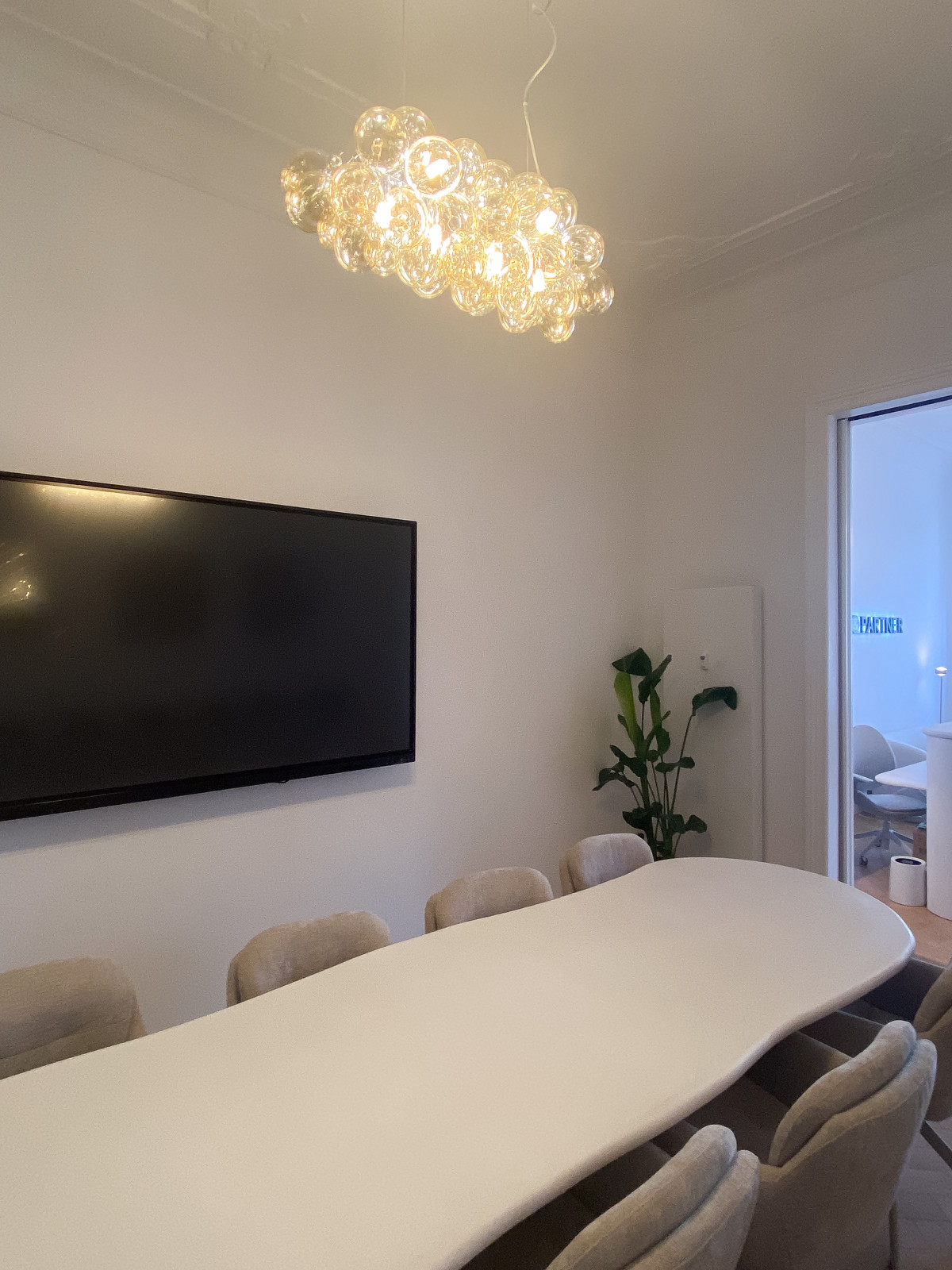 Konferenzraum mit Stühlen, einem organischen Tisch und Licht