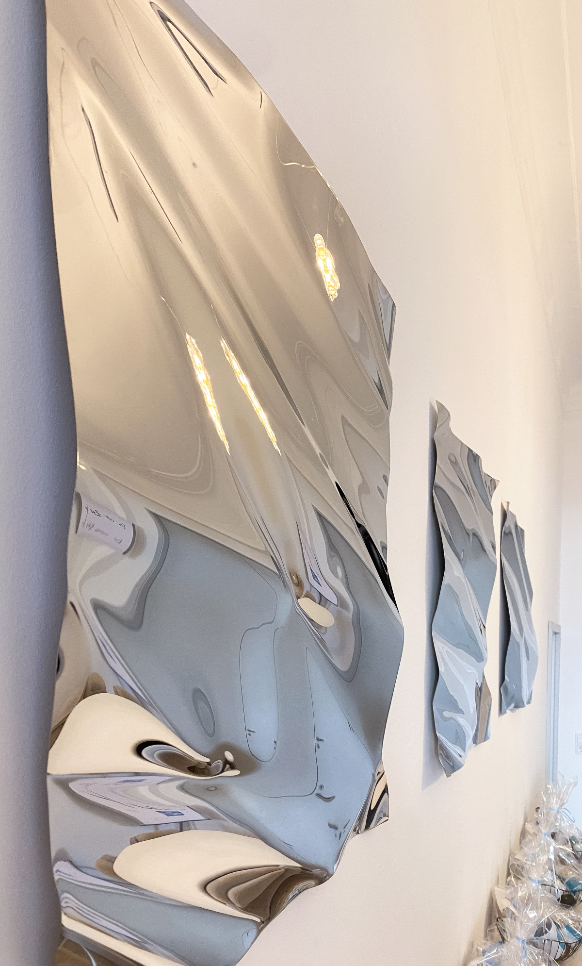 Verzerrte Spiegelkunst an heller Wand